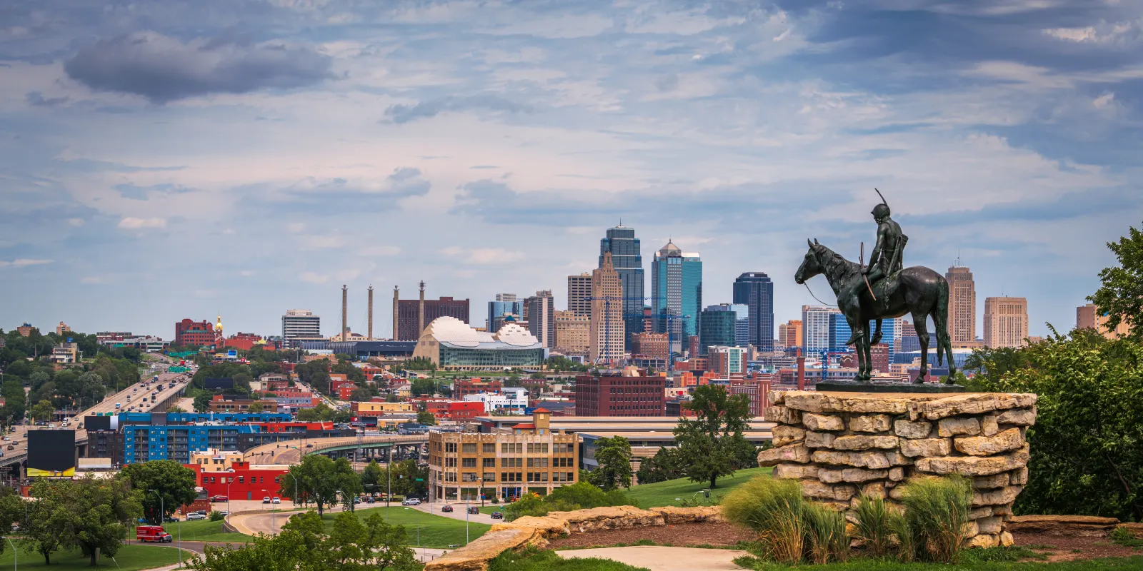 The Kansas City skyline from Penn Valley Park, with the Scout statue in the foreground.